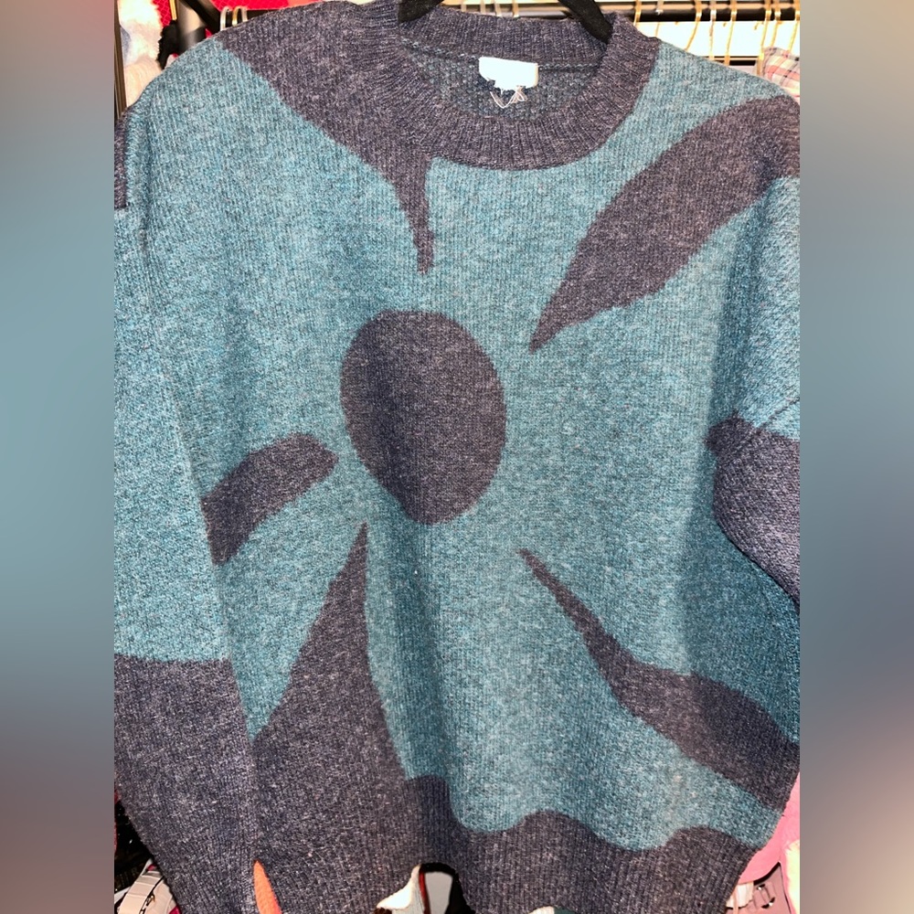 A sweater that’s been preloved and is a loose fitting for an XS